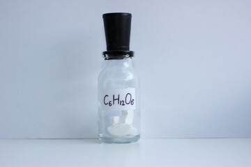 Glucose tablets in a closed glass jar with formula.