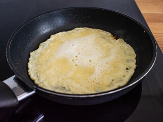 Sweet crepes frying in pan