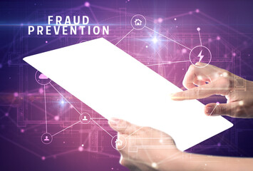 Holding futuristic tablet with FRAUD PREVENTION inscription, cyber security concept