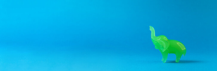 A jasper elephant is walking on a blue background.