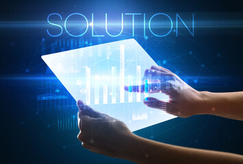 Hand holding futuristic tablet with SOLUTION inscription above, modern business concept
