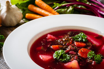 Borsch - beetroots soup with cream on wooden table
