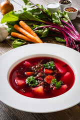 Borsch - beetroots soup with cream on wooden table
