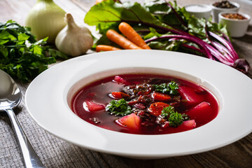 Borsch - beetroots soup with cream on wooden table
