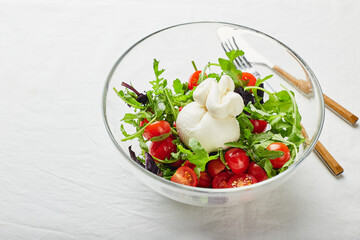 Burrata, Italian fresh cheese made from cream and buffalo or cow milk, with tomato, arugula and red basil salad