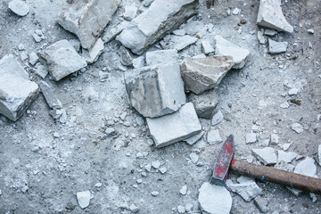 Broken brick and debris after repair and a hammer nearby.