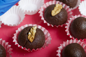 Dried fruit and nut sweets. Decorated with walnut swarms. Made at home in self-isolation during the epidemic. They lie in paper capsules.