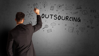 businessman drawing a creative idea sketch with OUTSOURCING inscription, business strategy concept