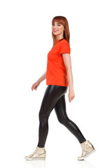 Fototapeta premium Smiling Young Woman Is Walking And Looking At Camera