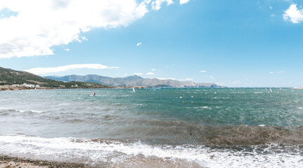 Catalonian coastal village Port de la Selva with Mediterranean sea and windsurfers, panoramic view