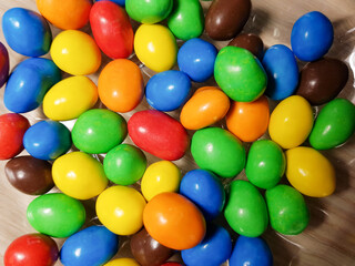 Multicolored chocolate-covered nuts in a transparent plate