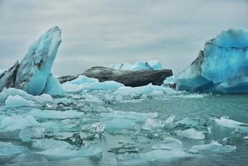 melting icebergs float in an ice lagoon in Iceland on a cloudy day
