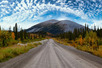 View of Scenic Road and Mountains on a Blue Cloudy Sky Fall Day in Canadian Nature. Taken near Tombstone Territorial Park, Yukon, Canada.