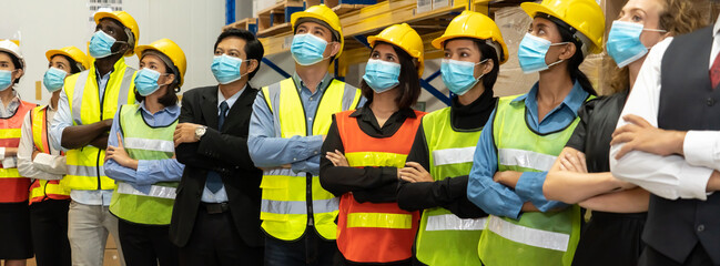 Group of factory industry worker working with face mask to prevent Covid-19 Coronavirus spreading during job reopening period .