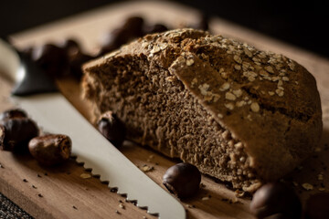 Autumn still life with homemade wheat bread and chestnuts on a wooden cutting board