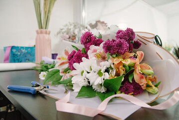 Florist equipment with flowers on wooden background