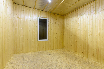 Interior of an empty country house, walls are decorated with wooden clapboard