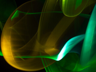 light painting photography, waves of vibrant color against a black background. Long exposure photo of vibrant fairy lights in abstract
