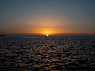 ship crosses the sea in the sunset