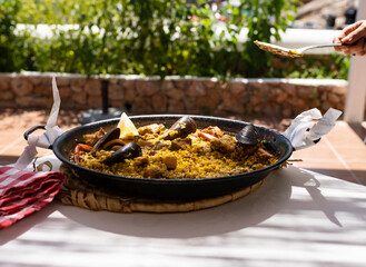 hands serving a spanish paella