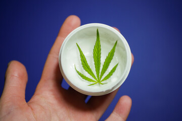 Hand holding CBD cream. Medical cannabis. Marijuana cosmetic 