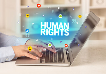 Freelance woman using laptop with HUMAN RIGHTS inscription, Social media concept