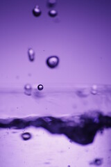 Krople wody podświetlone na fioletowo