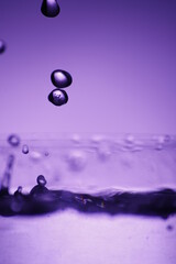 Krople wody podświetlone na fioletowo