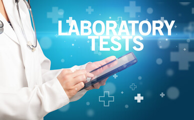 doctor writes notes on the clipboard with LABORATORY TESTS inscription, first aid concept