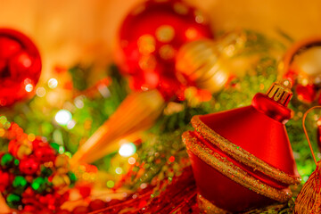 Soft focus  and sparkling Christmas ornaments surround a red and gold decoration.