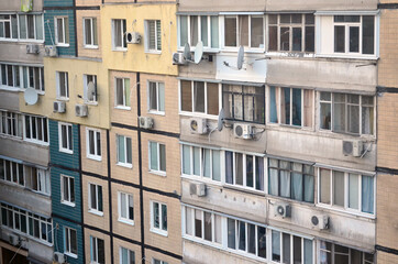 Fototapeta premium A beautiful order from the window in a residential area of ​​the city. High-rise buildings, sky and a ray of the setting sun.