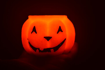 Festive orange candle pumpkin at night in the hands. Magic. Shine. Halloween. postcard, headband.