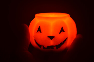 Festive orange candle pumpkin at night in the hands. Magic. Shine. Halloween. postcard, headband.