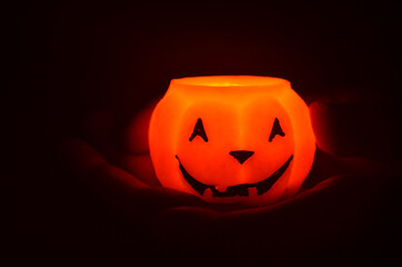 Festive orange candle pumpkin at night in the hands. Magic. Shine. Halloween. postcard, headband.