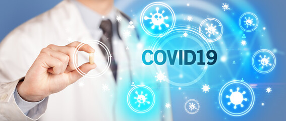 Doctor giving pill with COVID19 inscription, coronavirus concept