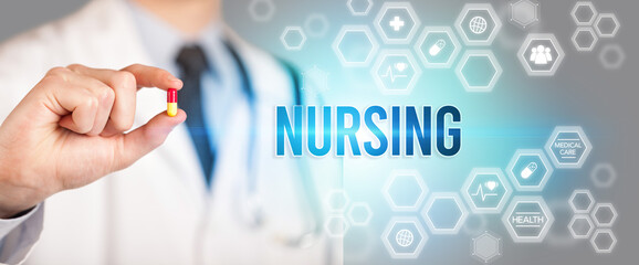 Close-up of a doctor giving you a pill with NURSING inscription, medical concept