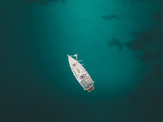 sailboat in the middle of mediterranean sea - aerial top down view