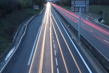 Train&eacute;es de lumi&egrave;res de phares de voitures au coucher du soleil sur le boulevard urbain sud de Lyon, ville de Corbas, d&eacute;partement du Rh&ocirc;ne, France