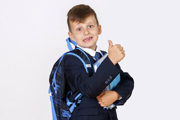 The student holds books in his hands and shows a hand gesture - class. Isolated on white background.