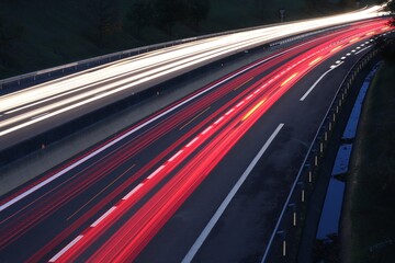 Trainées de lumières de phares de voitures au coucher du soleil sur le boulevard urbain sud de...