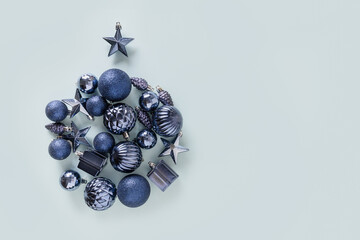 Christmas composition with blue decoration in bauble ornament shape on blue background. Top view. Xmas greeting card.