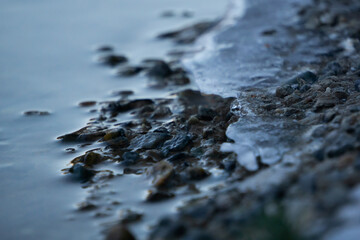 Wet stones covered by ice and water (close up)