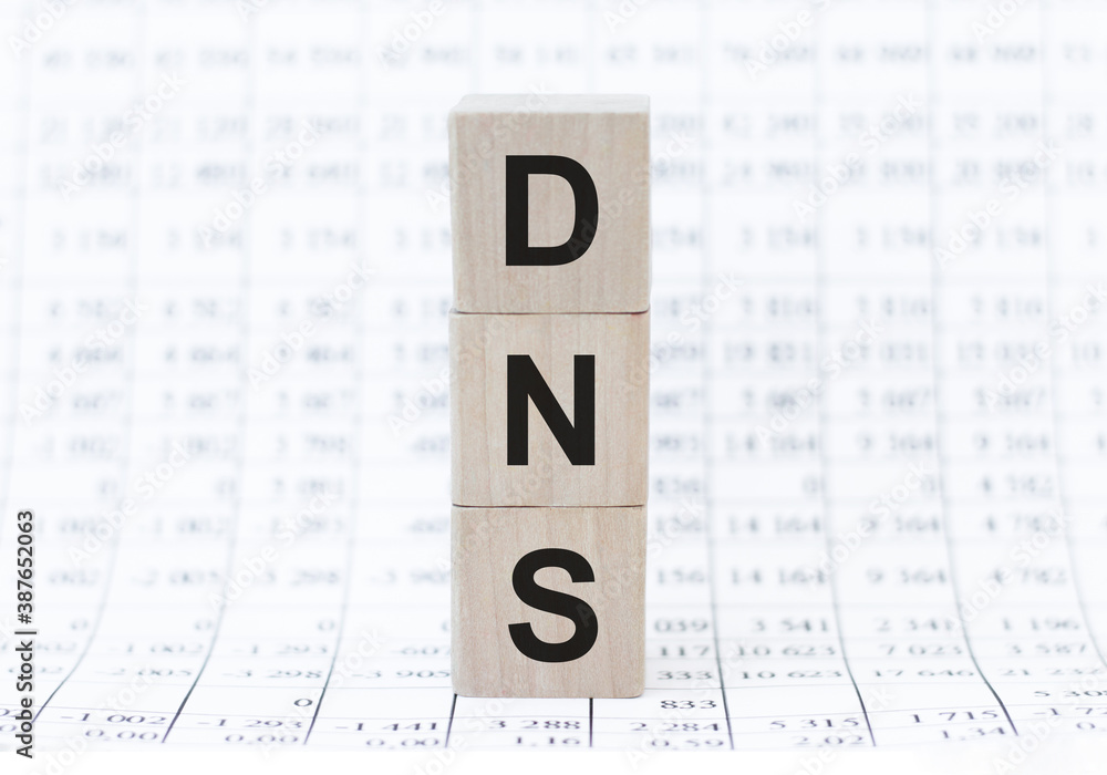 Poster three wooden cubes on the background of white financial statements, tables with the word dns domain 