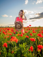 Young girl in a red dress in a poppy field
