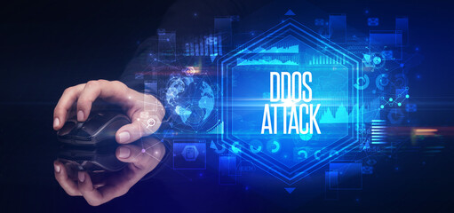 hand holding wireless peripheral with DDOS ATTACK inscription, cyber security concept