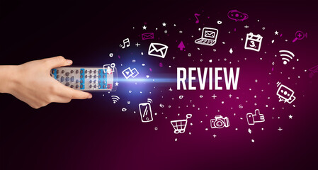 hand holding wireless peripheral with REVIEW inscription, social media concept