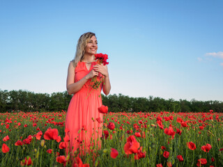 Young girl in a red dress in a poppy field
