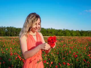 Young girl in a red dress in a poppy field
