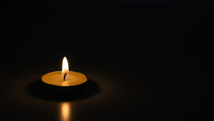Burning candle in the dark. A moment of sorrow.