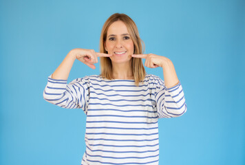 Fototapeta premium pretty young woman pointing her mouth over blue background.
